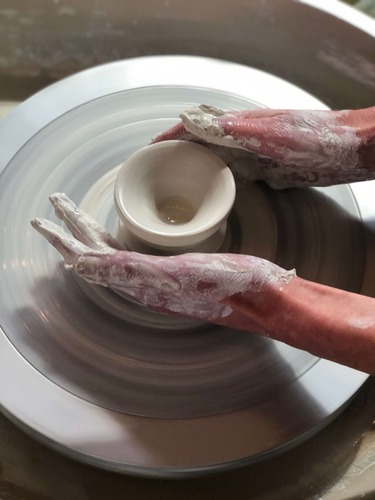 hand on the pottery wheel shaping a bowl